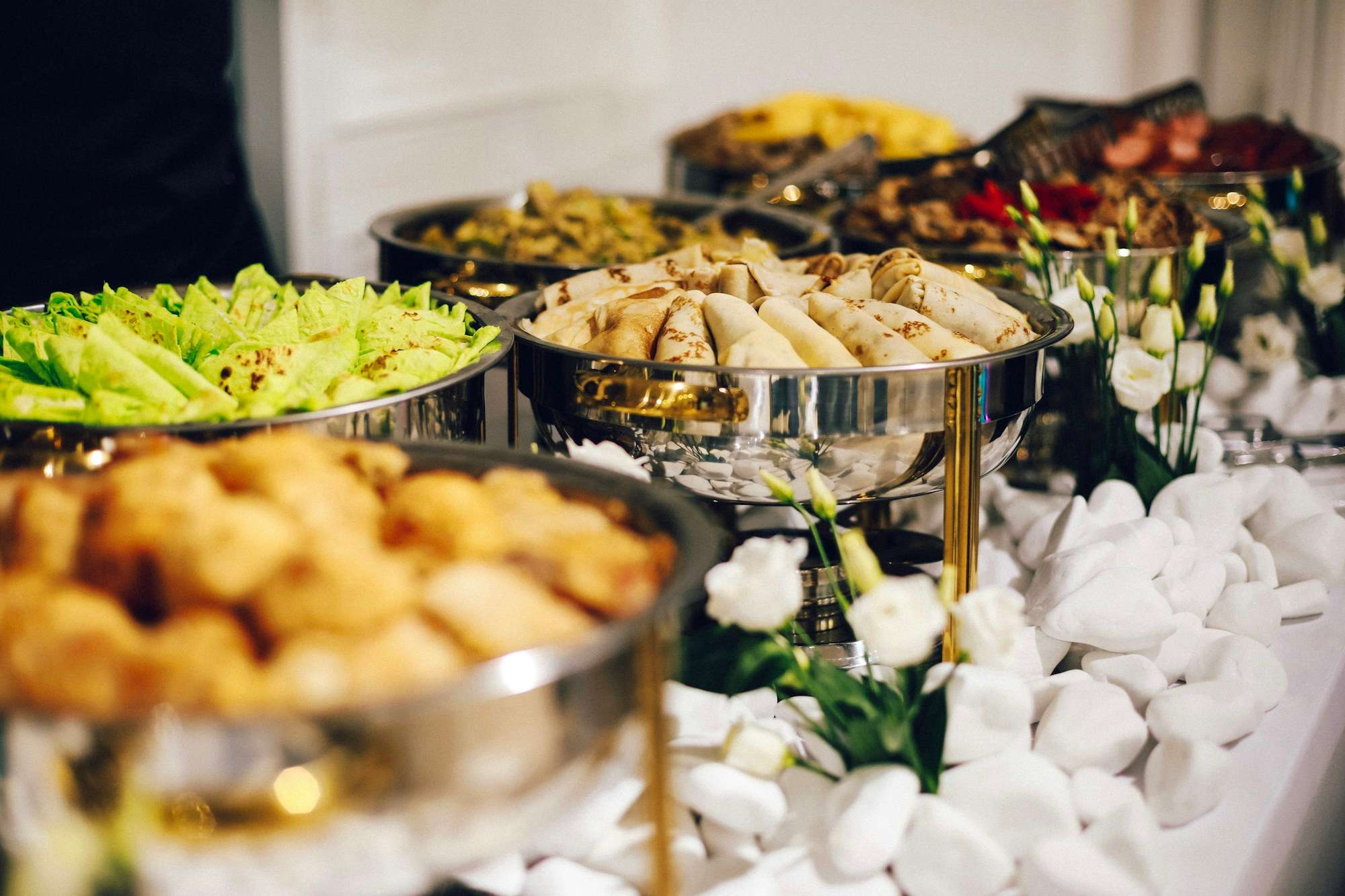 A buffet line with silver chafing dishes